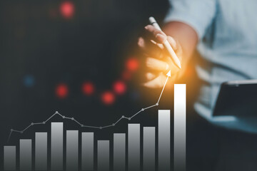 Businessman showing the growing stock of virtual holographic planning and stock market growth...