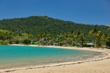 Tourquise beach with palm trees and playground in the hills
