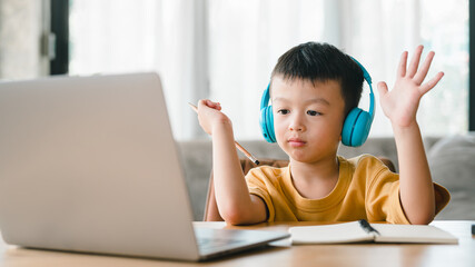 Asian boy student learning online learning online education video call .Happy boy study online with laptop at home. New normal life. Covid-19 or coronavirus. Social distancing. stay at home.