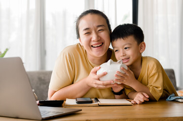 Family saving money concept, Asian Woman and son note family expenditures for a plan to spend the...