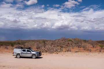 Fototapeta na wymiar An of-road vehicule on a dry Namibia road, Namibia