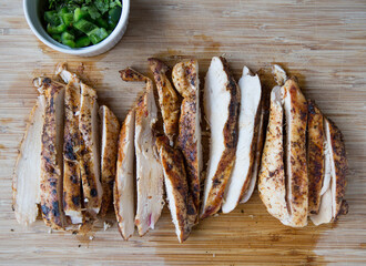 Sliced and juicy cooked chicken on a wooden board