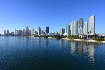 Obraz premium City of Miami, Florida skyline reflected in Biscayne Bay on calm winter morning under cloudless sky.