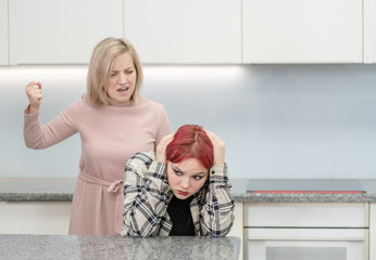 Family conflict. Angry mother screams at scared daughter