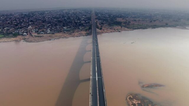 Flying over the Benue River bridge in Makurdi Town, West Africa with the smoggy city skyline on the horizon