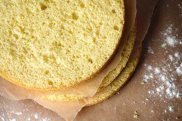 Cutting the biscuit into layers. Slicing sponge cake at home in the kitchen.