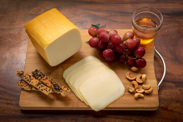 smoked mozzarella cheese block on wood board - 477246671