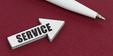 On a red background lies a white pen and a white arrow with the inscription - SERVICE