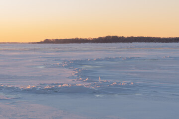 On the snowy bank of the river landscape. Winter snow scene. Winter river in the snow. Hummocks. A pile of ice fragments.