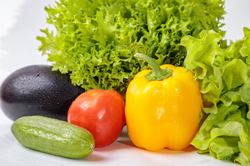 Set of fresh raw vegetables on a white background. Salad, tomatoes, cucumbers, eggplants, zucchini