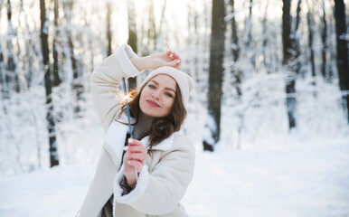 girl with sparkles Bengal fire in winter outdoor. Happy New Year concept. Christmas holiday