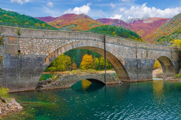 Villalago (Abruzzo, Italy) - A view of medieval village in province of L'Aquila, situated in the gorges of Sagittarius, with Lago San Domenico lake, bridge and sanctuary. Here during autumn foliage