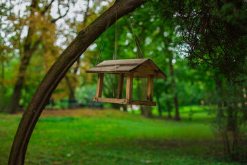 bird feeder wooden material object hanging on a tree branch, spring day