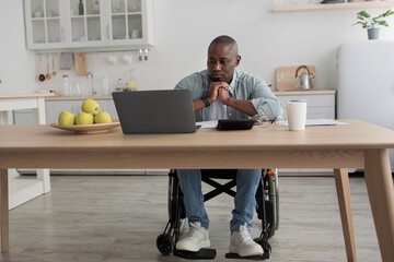 Pensive mature businessman send email, watch video lesson and work with taxes at home