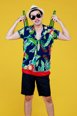 Young Asian boy in summer casual and hat enjoy drinking favorite tasty alcoholic beverage from glass bottle