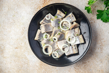 herring slice pieces of fish with onion seafood healthy meal food snack on the table copy space...