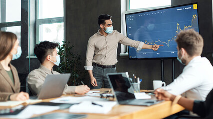 Colleagues having meeting in boardroom, arab businessman making presentation
