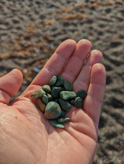 mans left hand full of jade stones found at a california beach