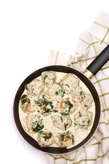 Delicious small meatballs with spinach in a creamy sauce in the frying pan