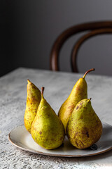 Fresh conference Pears on ceramic plate on white concrete  table, fruit background.