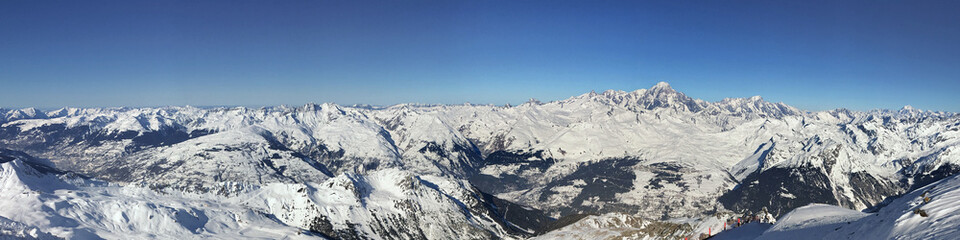 Obraz premium panoramic view on peak mountain range covered with snow and under blue sky in Tarentaise, Savoie