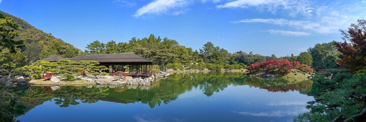 Fototapeta na wymiar 青空バックに見る日本庭園の紅葉パノラマ情景＠栗林公園、香川