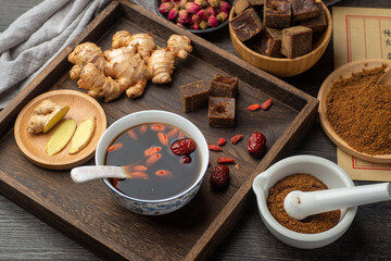 Brown sugar ginger jujube tea and Chinese classical medical books on the table