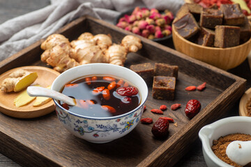 Brown sugar ginger jujube tea and Chinese classical medical books on the table