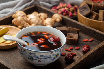 Brown sugar ginger jujube tea and Chinese classical medical books on the table