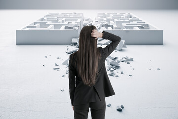Back view of businesswoman in suit looking at white maze. Solution and challenege concept.