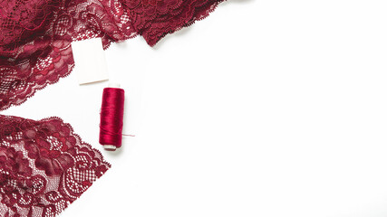 Sewing women underwear, made of red, burgundy lace on table