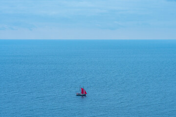 Scarlet sails on a yacht on the blue sea in the distance