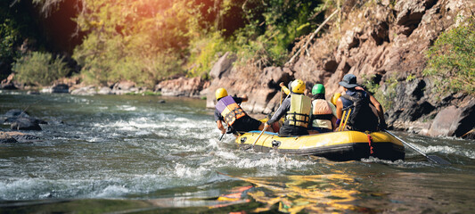 people rafting on the river turbulent flow with sunbeam. Extreme and enjoyment sport.