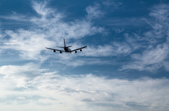 Silhouette of an airplane flying isolated on cloudy sky day background.