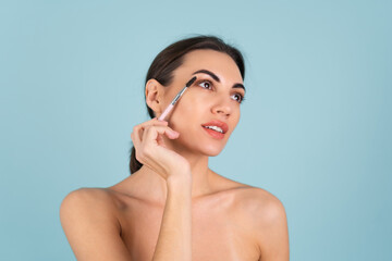 Close up beauty portrait of a woman with perfect skin and natural makeup, full nude lips, holding an eyebrow brush