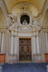 Entrance wooden door of the Church of Saint Mary of the Announcement/ Chiesa parrocchiale della Santissima Annunziata in Parma, Italy