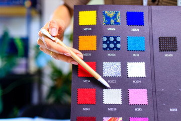 dressmaker woman working with color samples for selection new clothing collection
