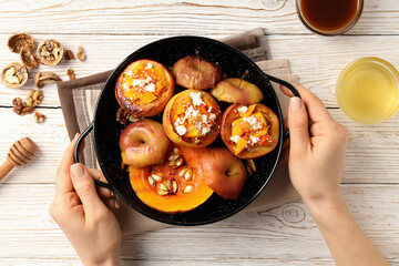 Concept of tasty food with baked apple on white wooden background