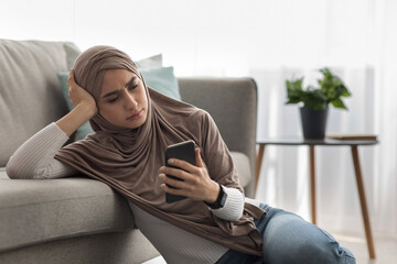 Woman upset after reading bad message on phone at home
