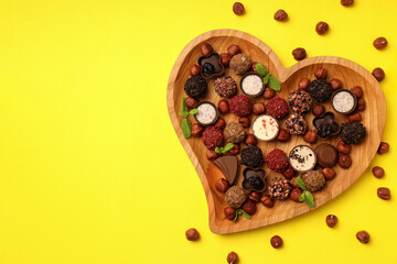 Concept of sweets with chocolate candies on yellow background