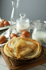 Concept of cooking crepes on white wooden table