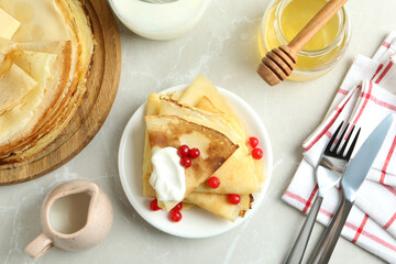Concept of tasty food with crepes on light textured background