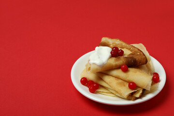 Concept of tasty food with crepes on red background