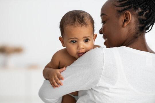 Happy African American lady hugging her cute child
