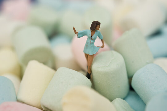 Miniature Figurine Of A Woman Standing On Marshmallow