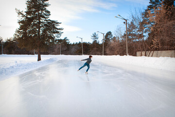 figure skater on ice. the girl is skating. ice under the open sky. No makeup in winter, red cheeks