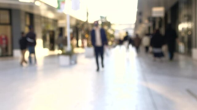 ぼかし背景素材: マスク姿の人々が行き交うショッピングモールの風景  4K 2021年12月広島市郊外のショッピングモールにて撮影