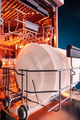 Clean plates after washing in the dishwasher. Close-up of the dishes placed in the dishwasher