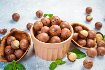 Macadamia nut. Macadamia nuts in a shell, in a bowl. On a stone background. Macadamia nuts are rich in various trace elements and vitamins.