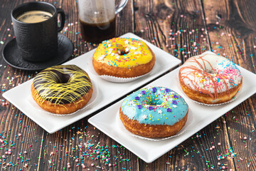 Delicious donuts decorated with different decorations on wooden table
